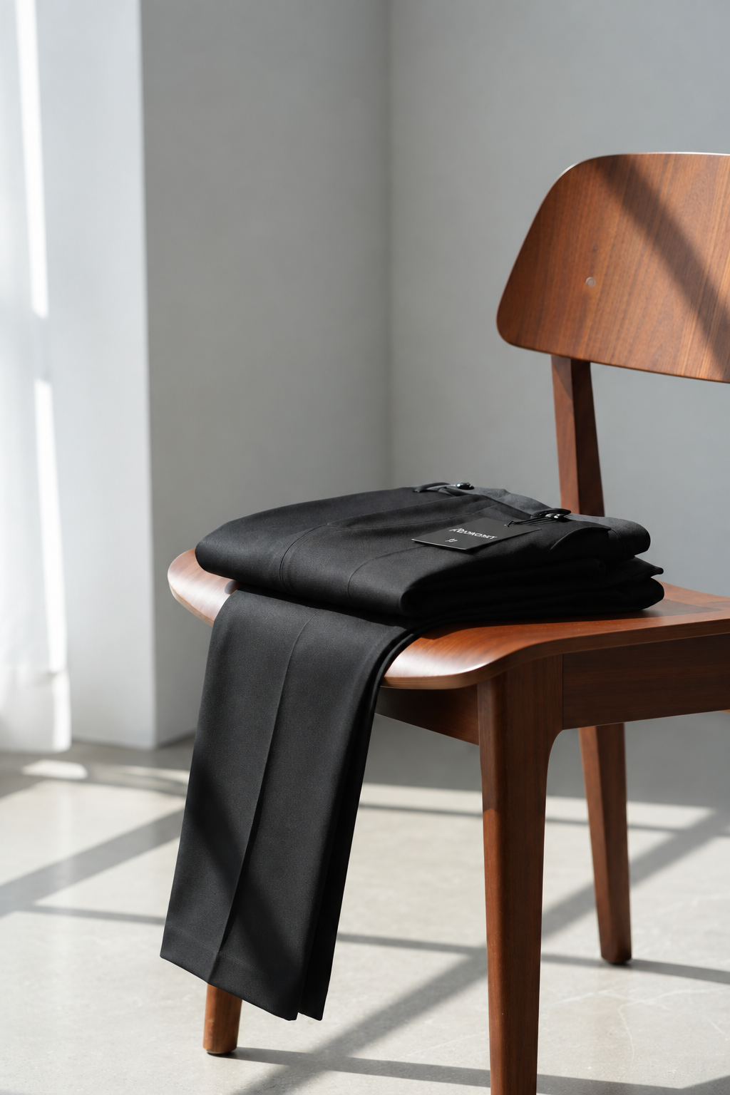 Foto vertical optimizada del pantalón negro sobre la silla